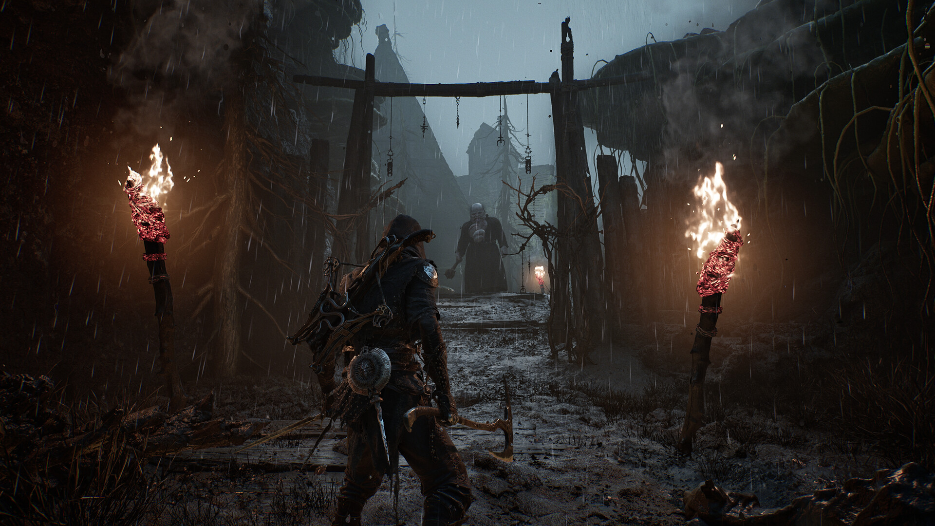 The player approaching a gateway in the rain with fiery torches either side and a monster in the distance