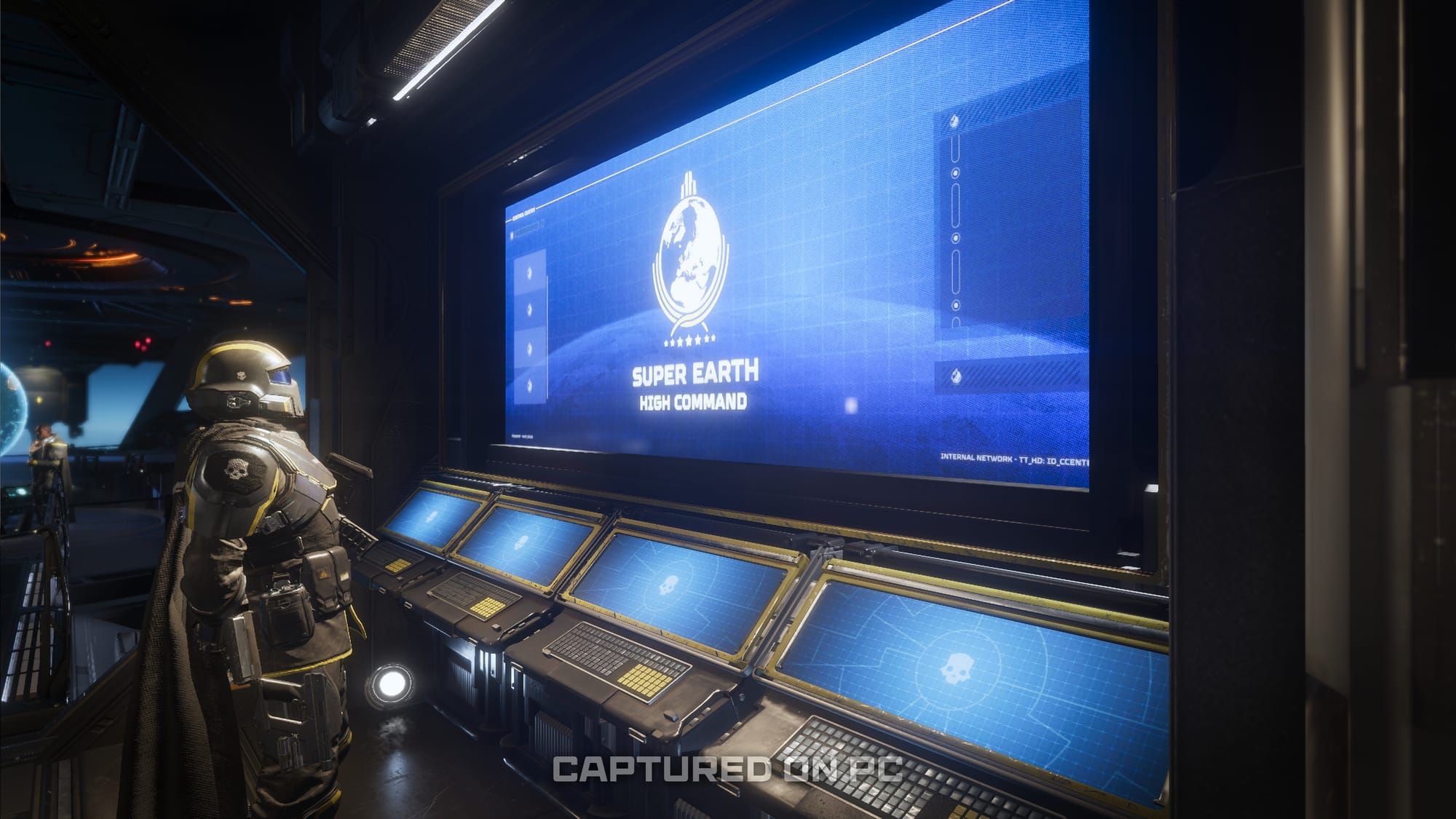 A Helldiver examines a new Super Earth High Command console on their Super Destroyer in a WIP screenshot from an upcoming update.