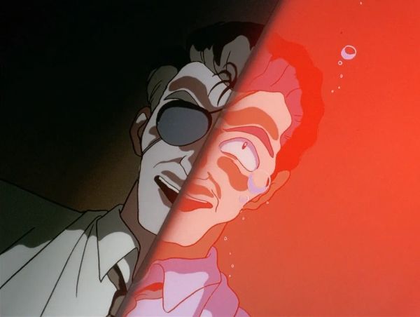 A mad scientist looking character with an eyepatch stands with half of his face obscured behind a red, bubbling tube of liquid.