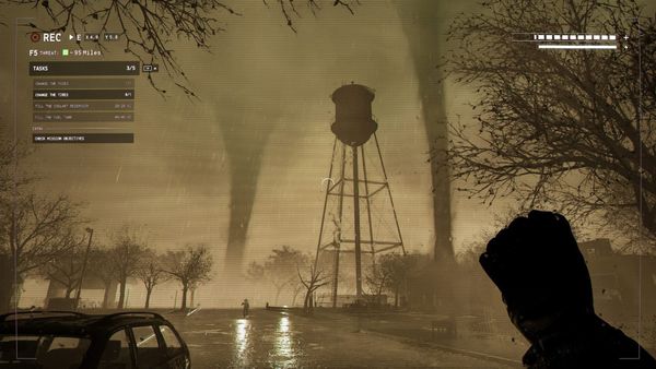 A screenshot showing two tornadoes around a water tower
