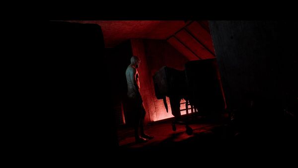 A menacing humanoid creature stands in a room starkly lit in red and largely cloaked in shadow in a screenshot from Silent Hill Townfall