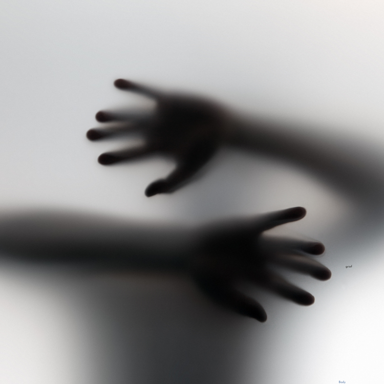 Hands pressing against a cloudy window. 