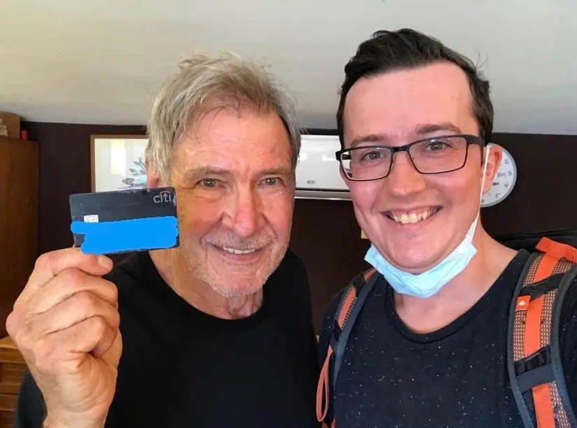 Harrison Ford with tourist Simon Milewski who returned his credit card. They're both smiling for a selfie and Harrison is hol