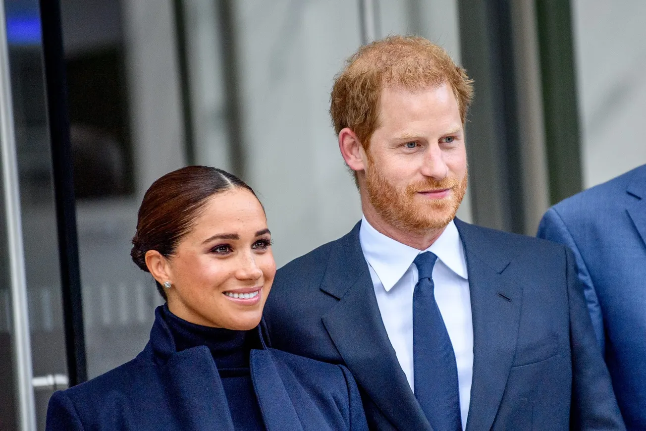 Prince Harry and Meghan smile at a press event together