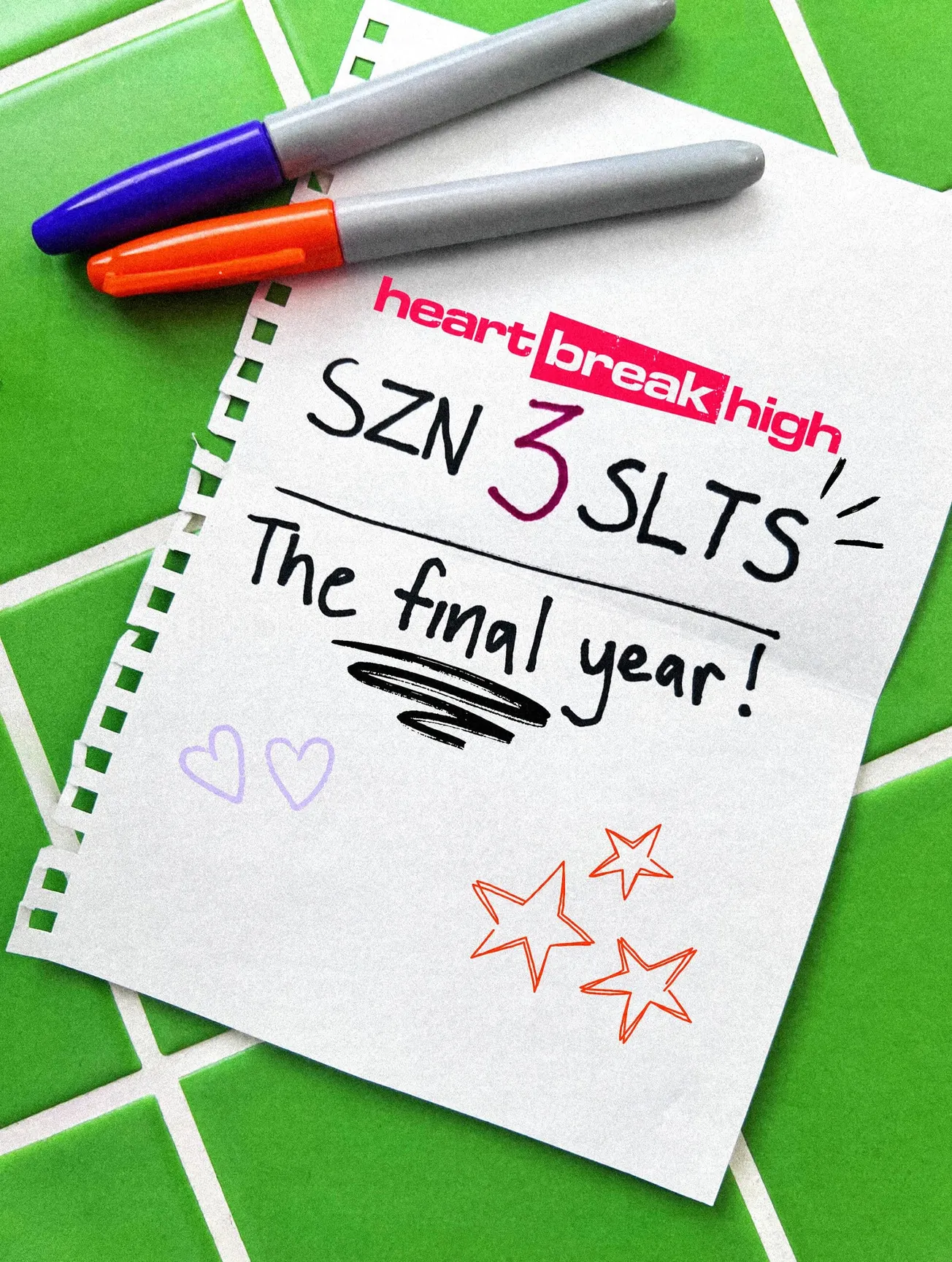 promo shot for Heartbreak High season 3 with pens beside it. On the paper it reads "SZN 3 SLTS, The Final Year."