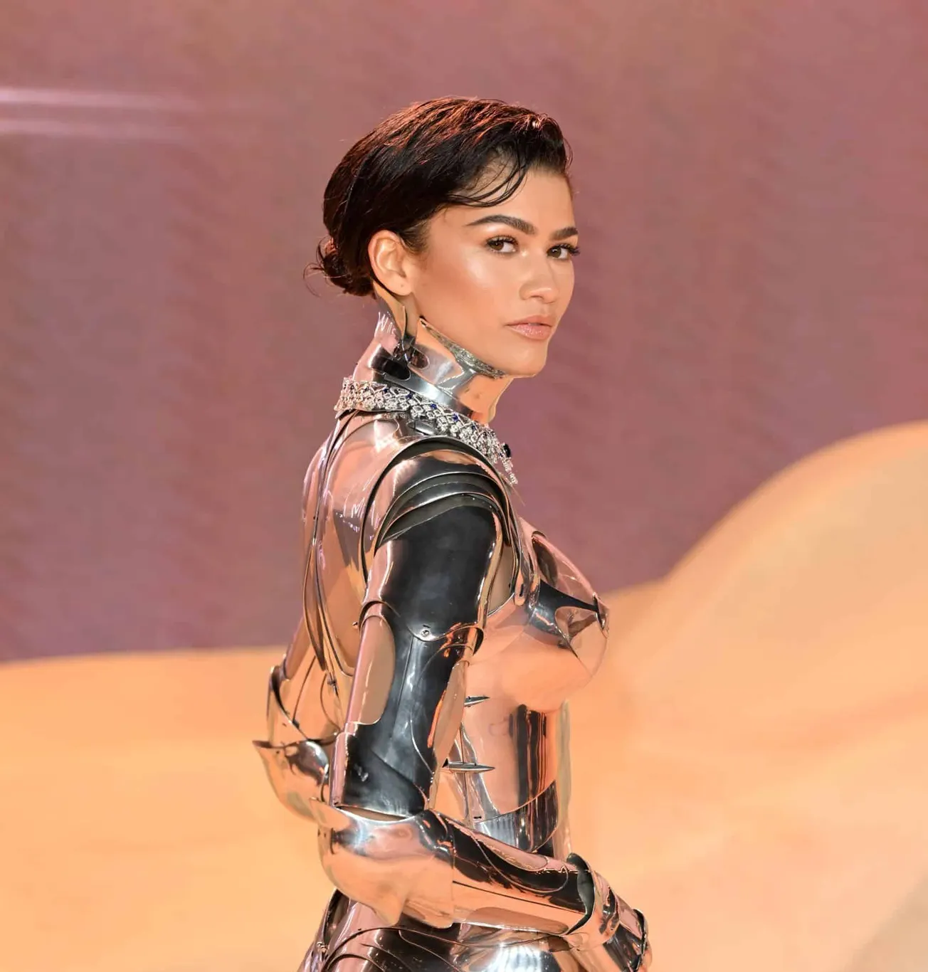 Zendaya in metallic robot outfit at 'Dune 2' premiere on a sandy red carept
