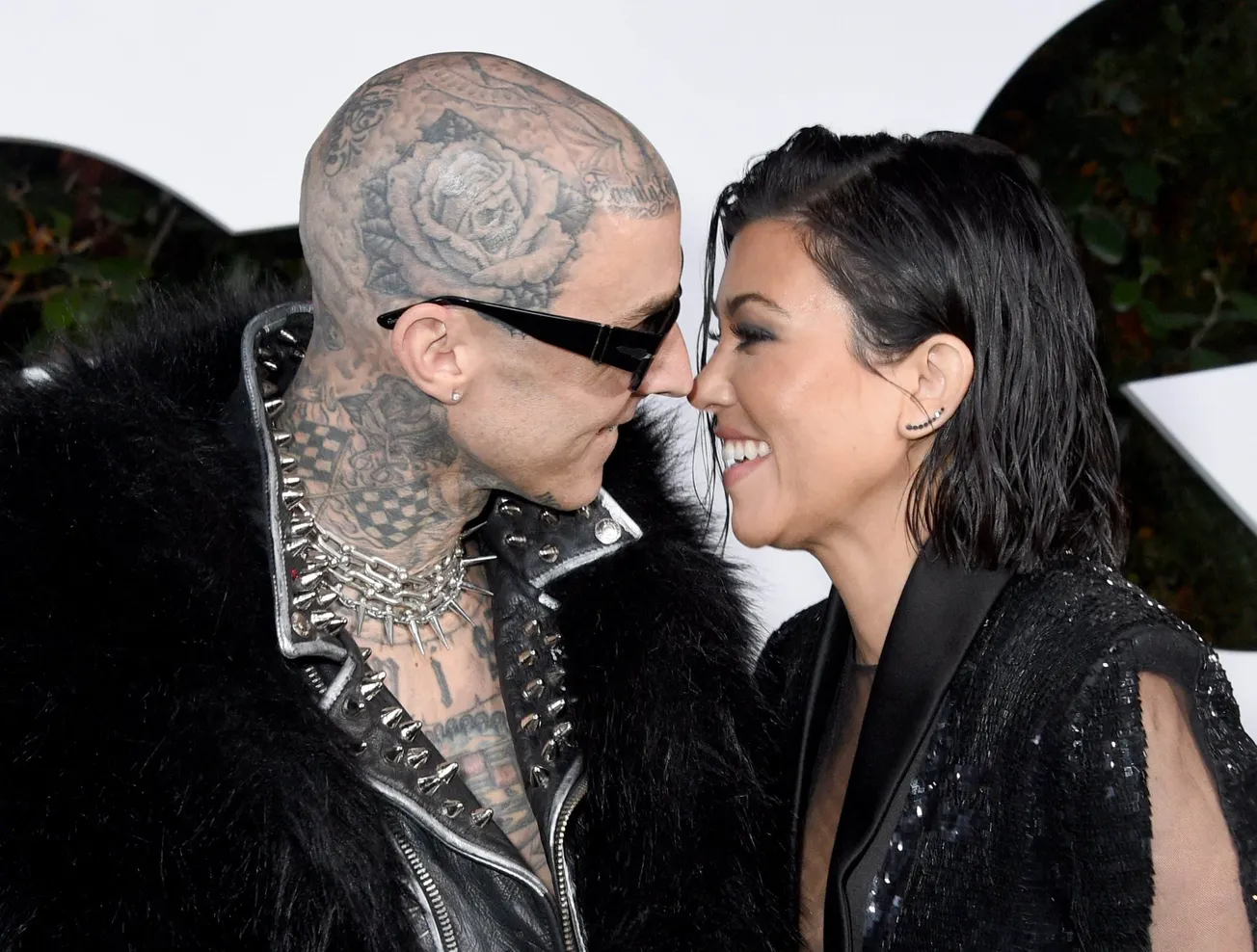 Travis Barker and Kourtney Kardashian reveal sex of their baby. This photo shows Travis and Kourtney looking at each other an