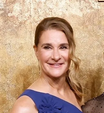 a close up image of Melinda French Gates smiling at a red carpet event. She wears a blue dress and has brown hair