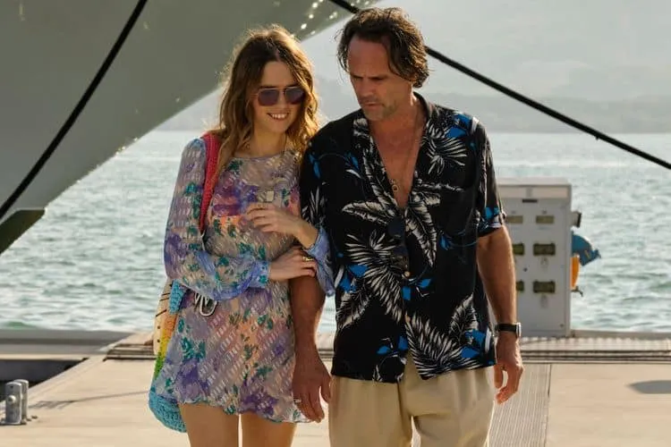 A still from The White Lorus season 3 showing AImee Lou Wood's character Chelsea and Walton Goggins' character Rick walking t