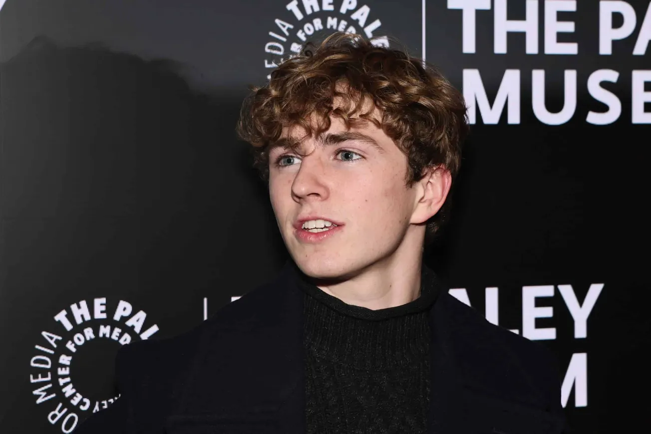 a close up of Walker Scobell at a red carpet event, dressed in all black.