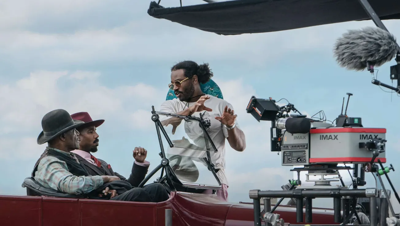 Delroy Lindo and Michael B Jordan sitting together as Ryan Coogler directs them on the set of 'Sinners'