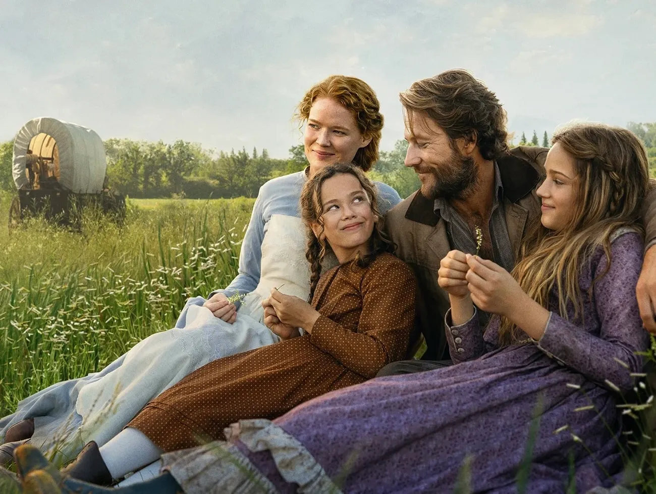 Little House on the Prairie Netflix promo shot showing the Ingalls family sitting together in a grassy field