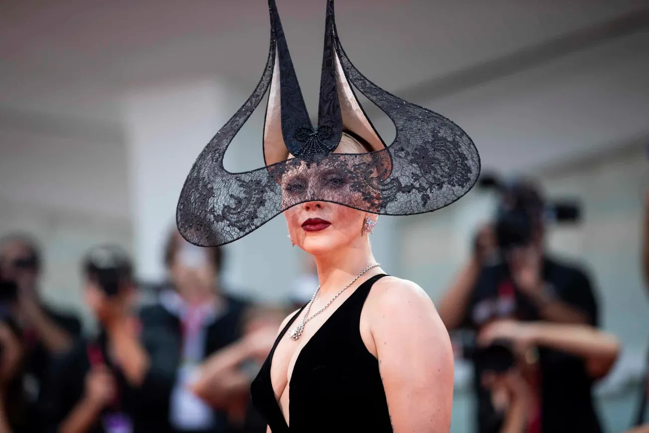 A close up of Lady Gaga wearing striking black lace headpiece at the Venice Film Festival, 2024