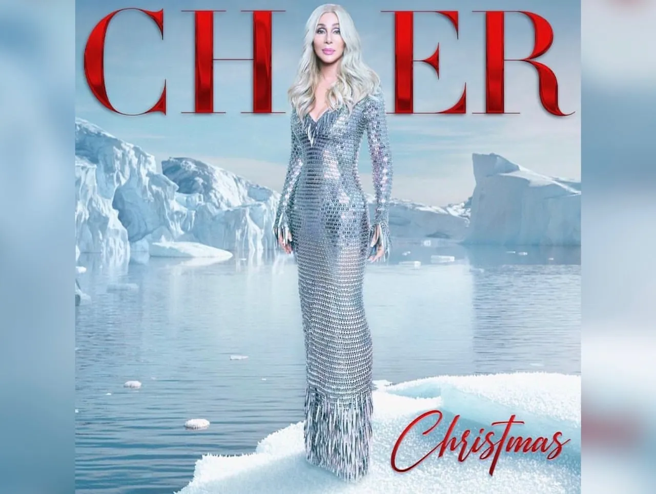 Cher Christmas album featuring the singer in a sparkling silver dress surrounded by a winter background.