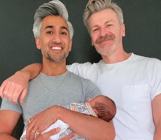 Tan France and Rob France smiling with baby Ismail in Tan's arms.