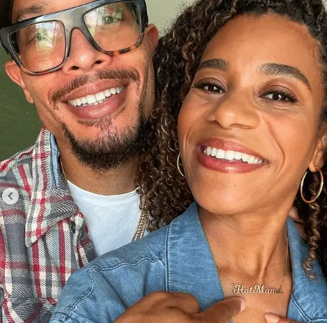 Pete Chatmon and Kelly McCreary smile and point to kelly's necklace which reads "hot mama"