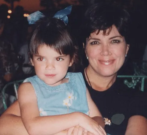 Kris Jenner smiles while holding baby Kendall Jenner