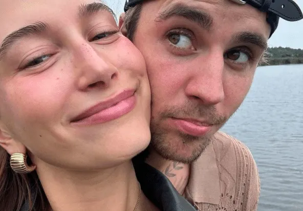 a selfie of Hailey Bieber and Justin Bieber smiling with their heads together.