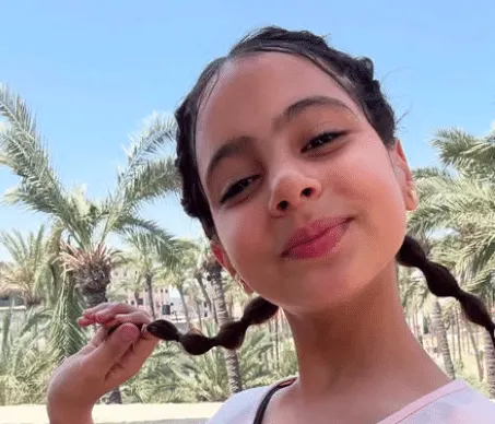 a close up of Renad from Gaza, a young girl with her hair in braids, taking a selfie.