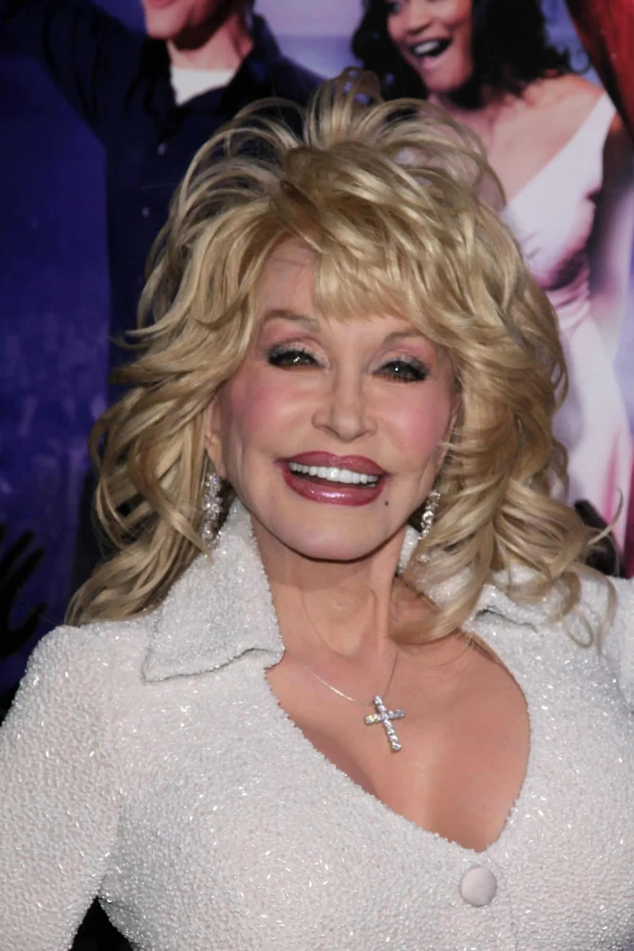 Dolly Parton smiling at a red carpet eveng with her signature big, blonde hair.