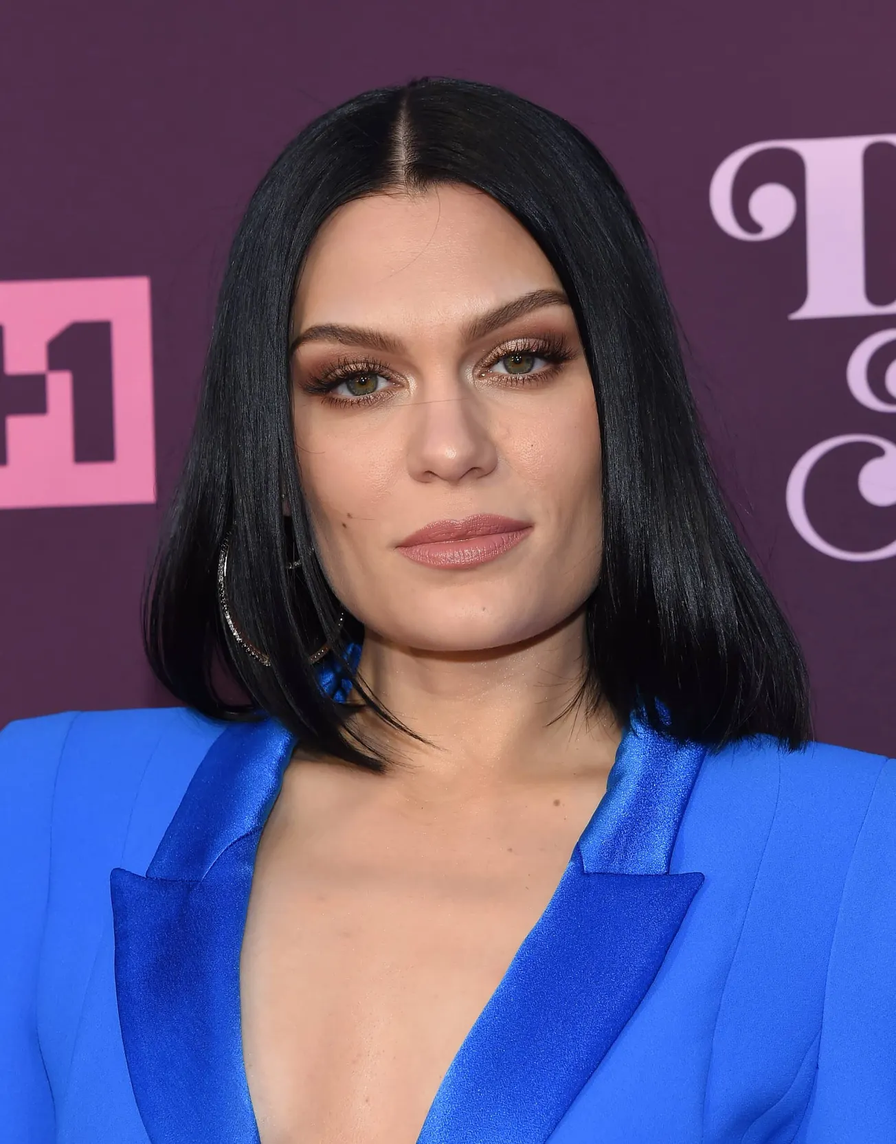 A close up of Jessie J wearing an electric blue suit at a press event,