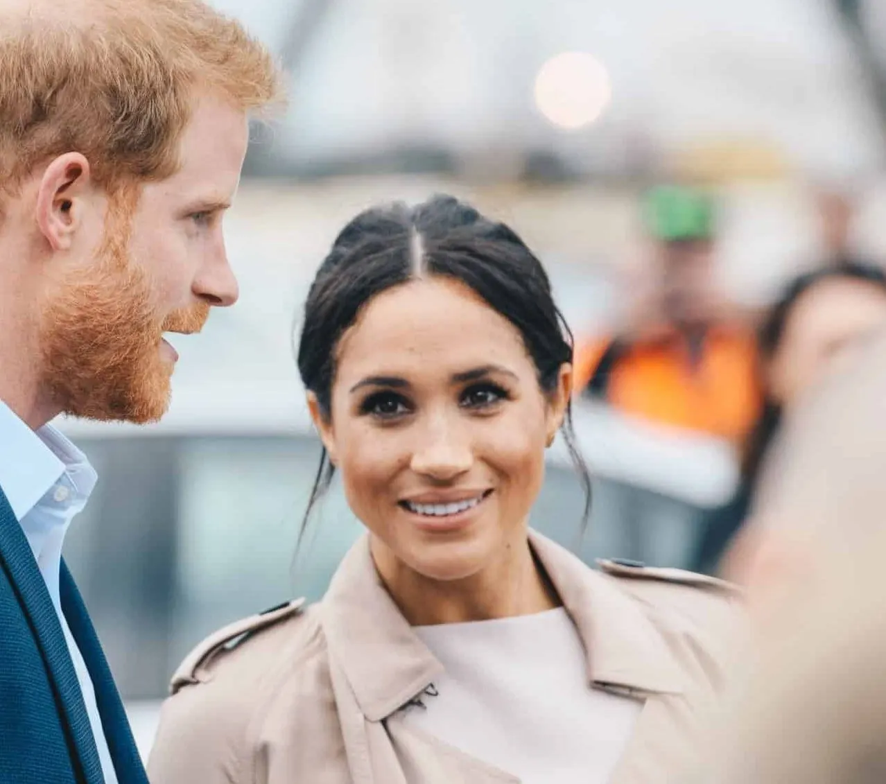 A photo of Harry looking towards Meghan at an outdoor press event. Today Meghan has launched American Riviera Orchard, her ne