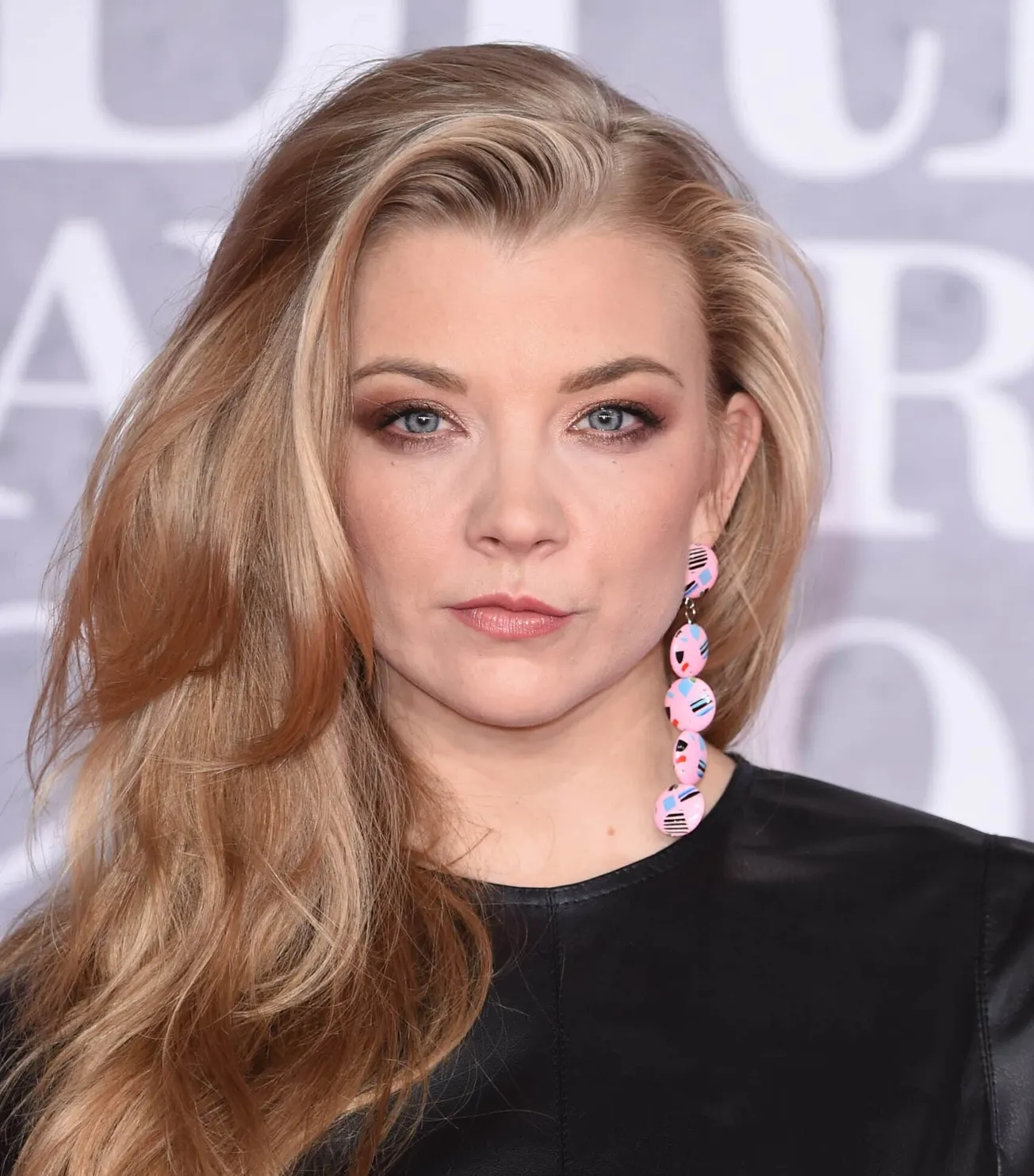a close up of Natalie Dormer with her long blonde hair on one shoulder, at a press event in 2019