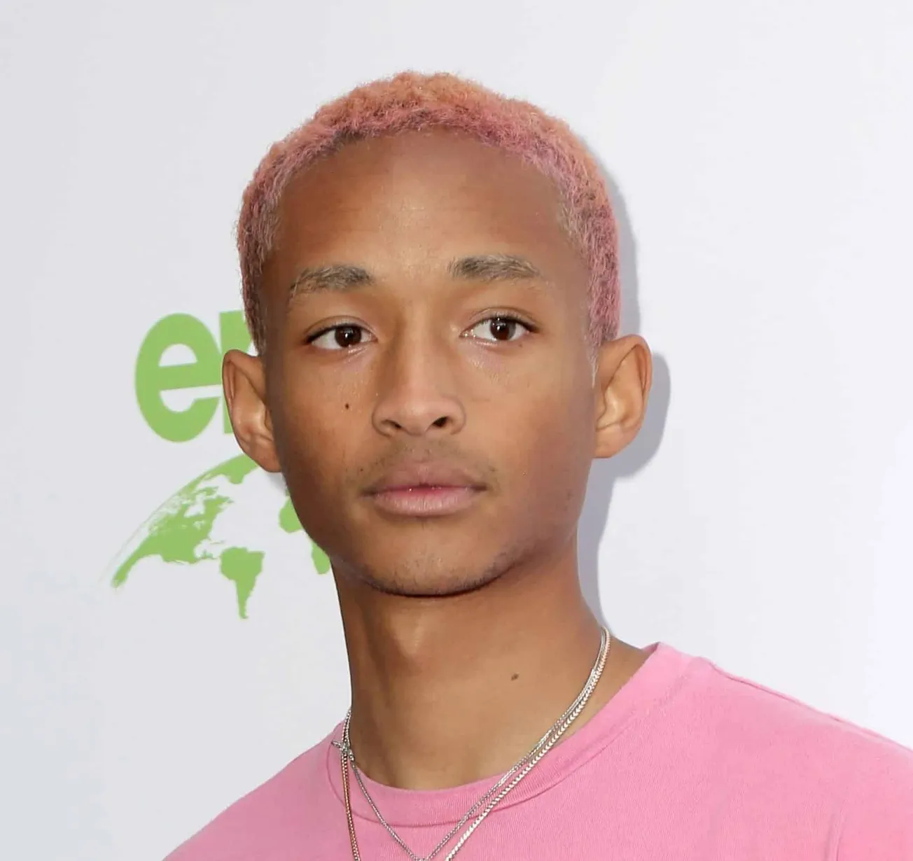 Jaden Smith attends a red carpet event. He has pink hair and wears a pink T-shirt.