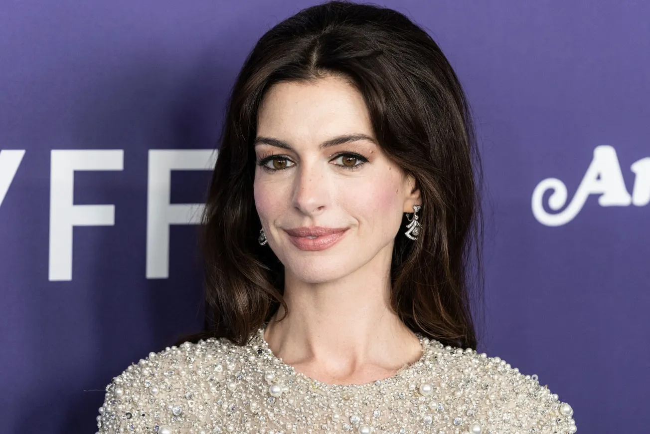 a close up of Anne Hathaway at a red carpet event. She has bouffant, long, brown hair that sits behind her shoulders.