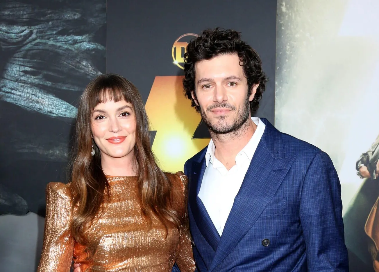 Leighton Meester smiles with husband and 'Nobody Wants This' star Adam Brody at a press event. She wears a sparkling brown go