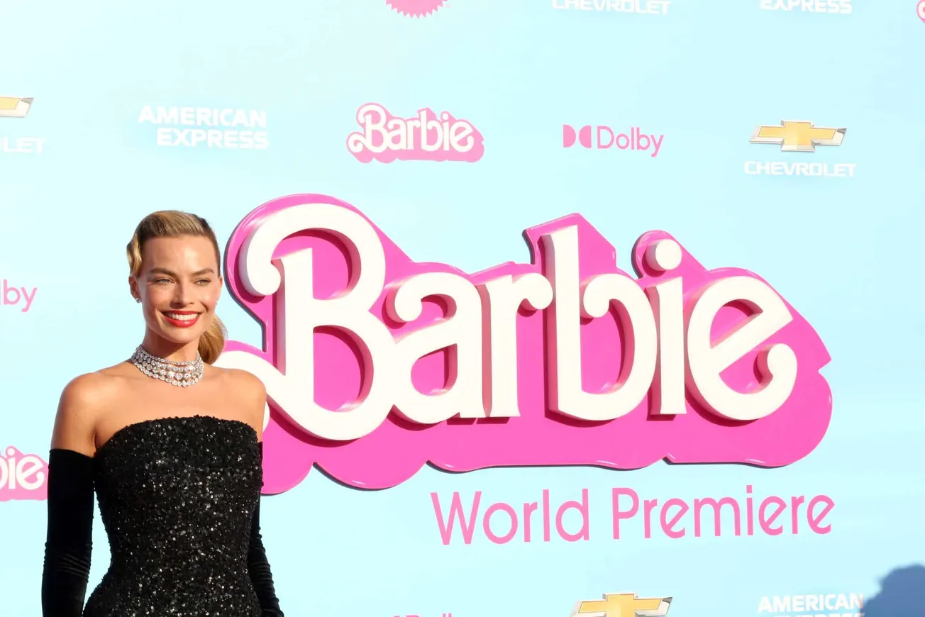 Margot Robbie dressed in black strapless dress with long black gloves, during the 'Barbie' press tour.