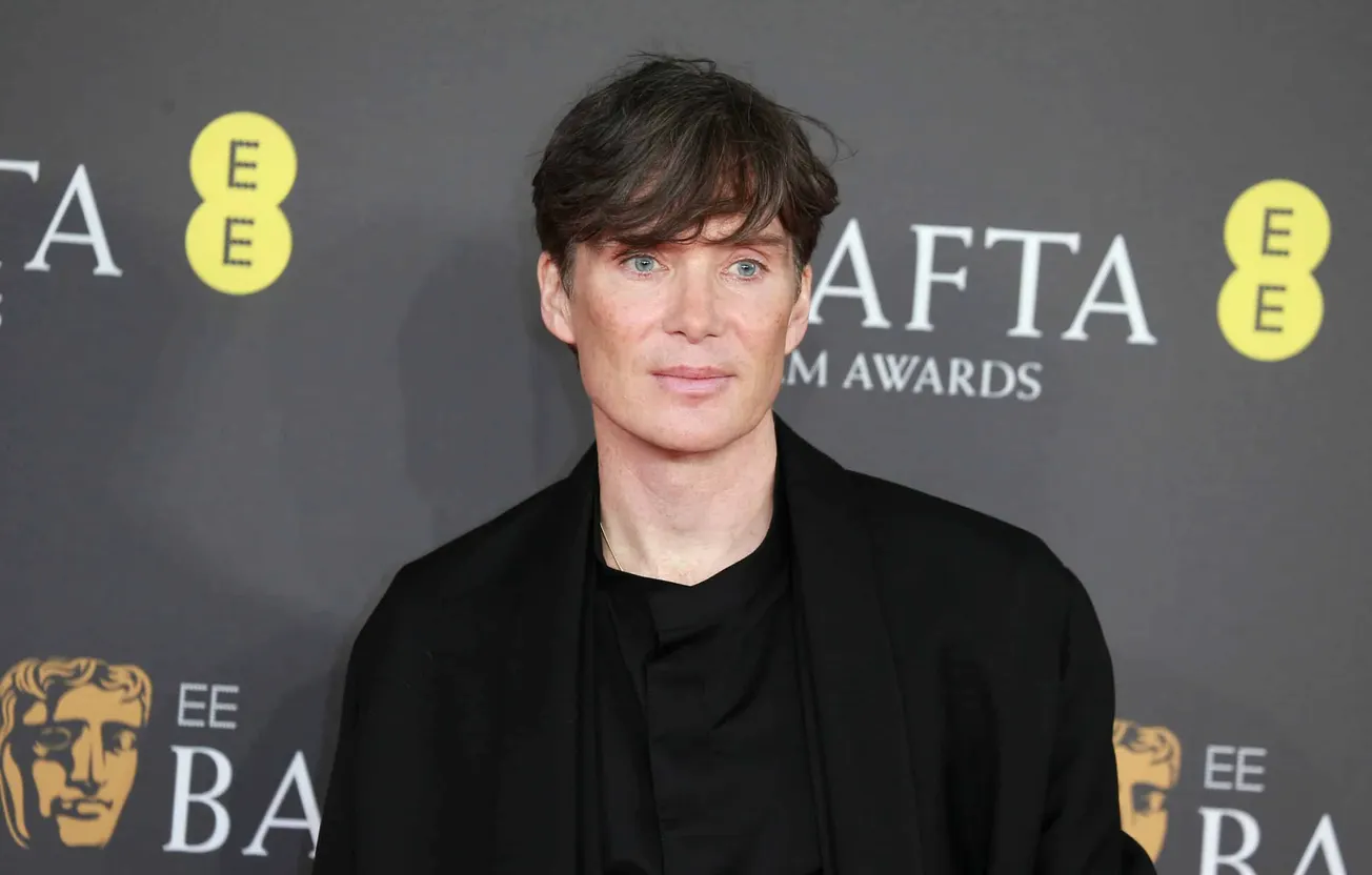 Peaky Blinders star Cillian Murphy smiles at a red carpet event in 2024. He is dressed in a black suit and tshirt.
