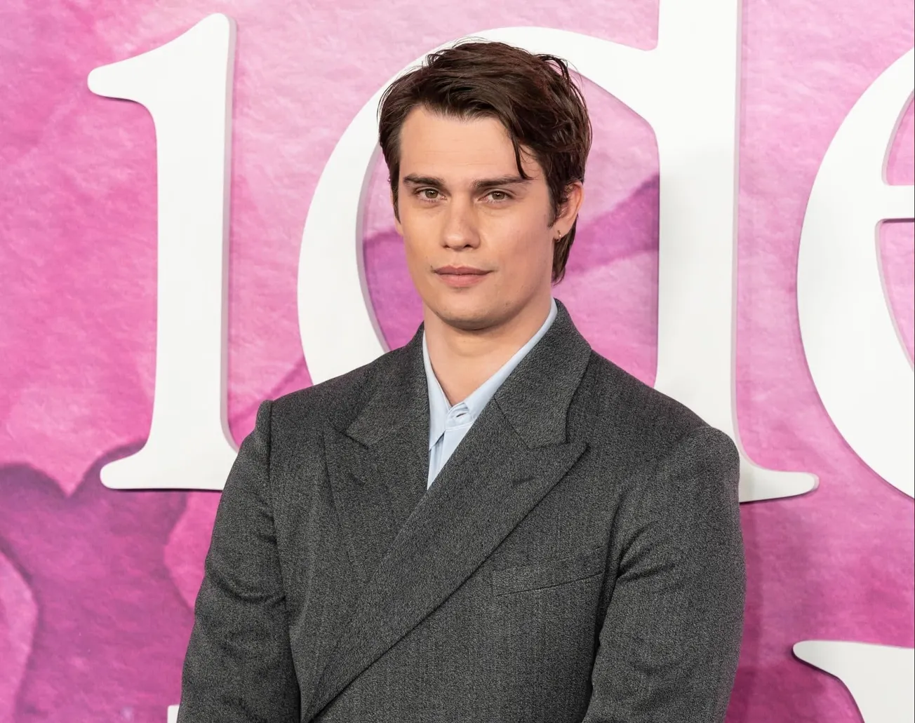 New "He-Man' star Nicholas Galitzine poses for a photo at a red carpet premiere for his movie "The Idea of You'. He wears a g