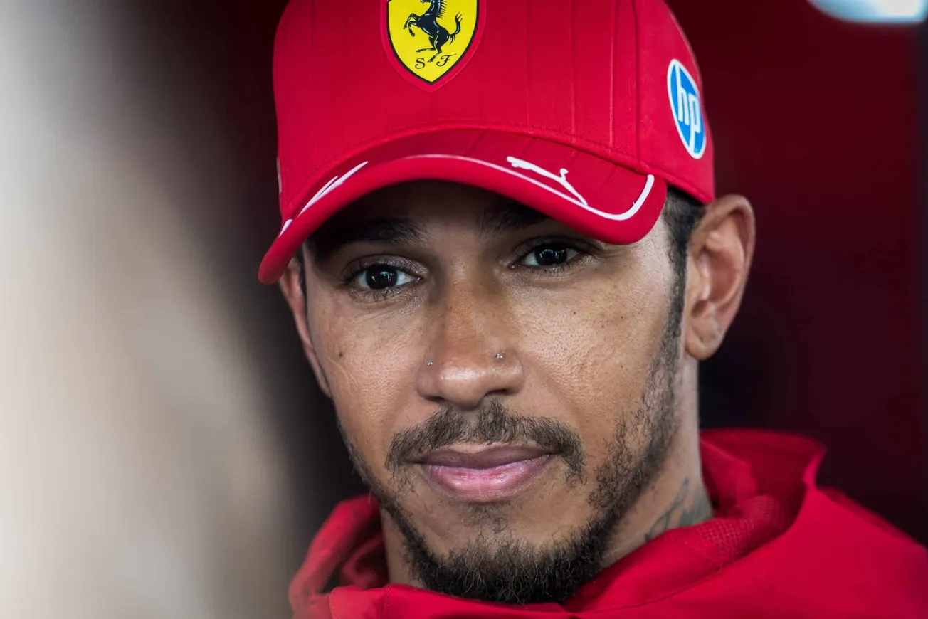 Lewis Hamilton wearing his red Ferrari cap and gear