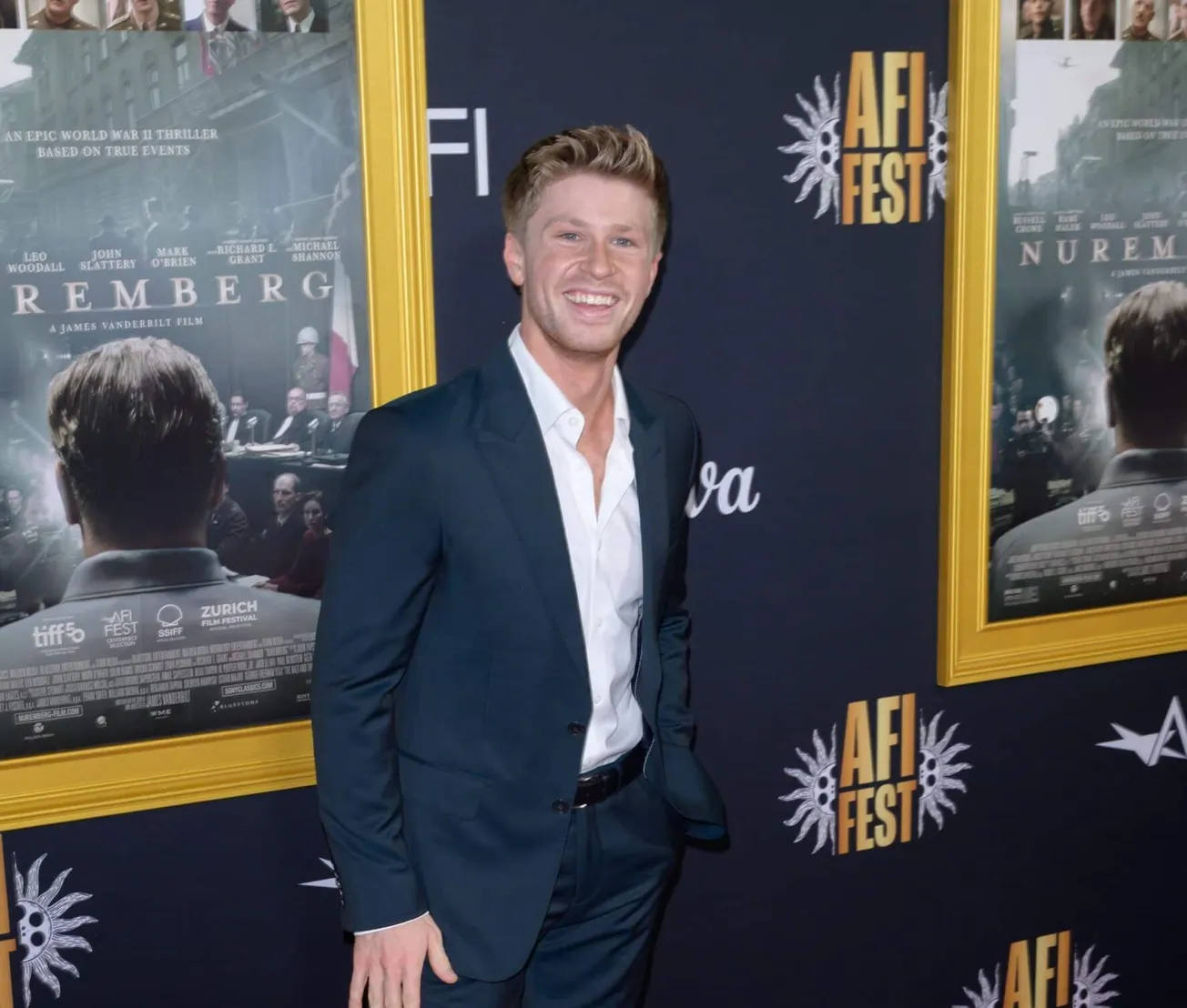 Robert Irwin smiles at a press event wearing a dark suit