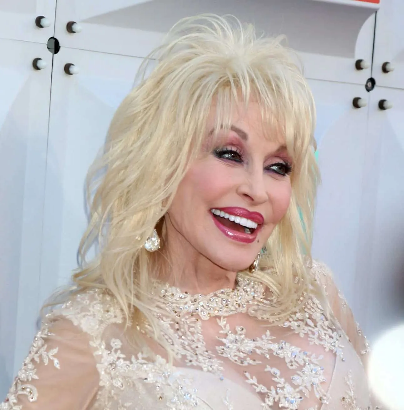 a close up of Dolly Parton smiling at a press event.