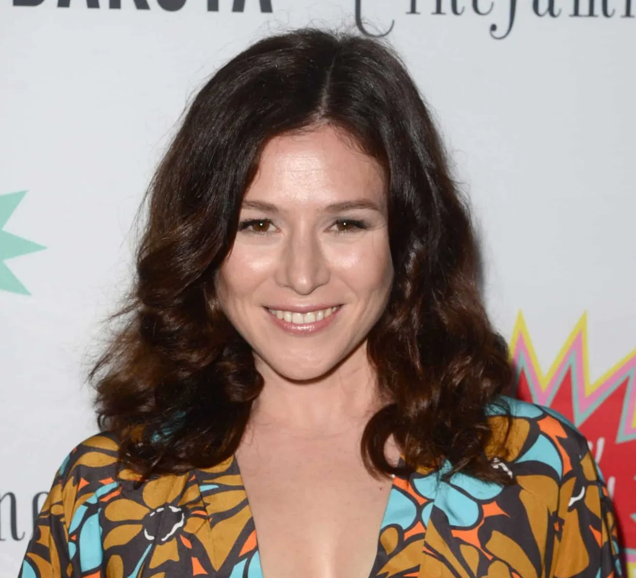 Yael stone smiles at a press event.