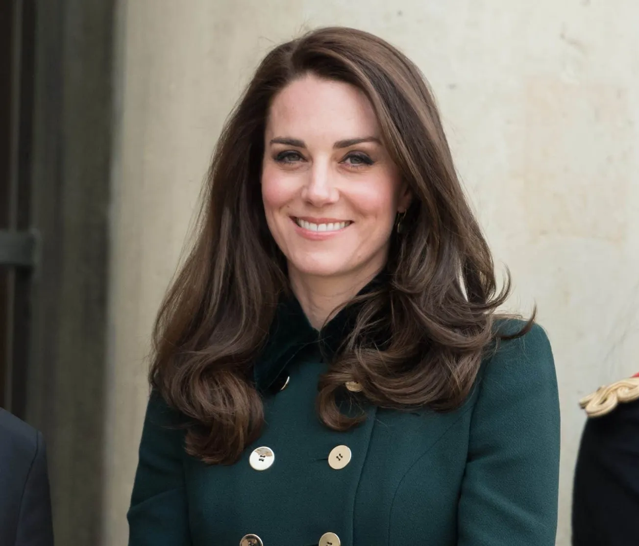 A smiling Catherine, Princess of Wales wearing a buttoned coat.