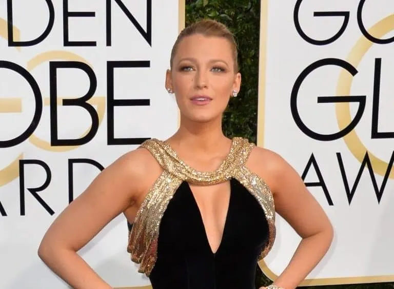 Blake Lively at the Golden Globes red carpet wearing a gold and black dress.