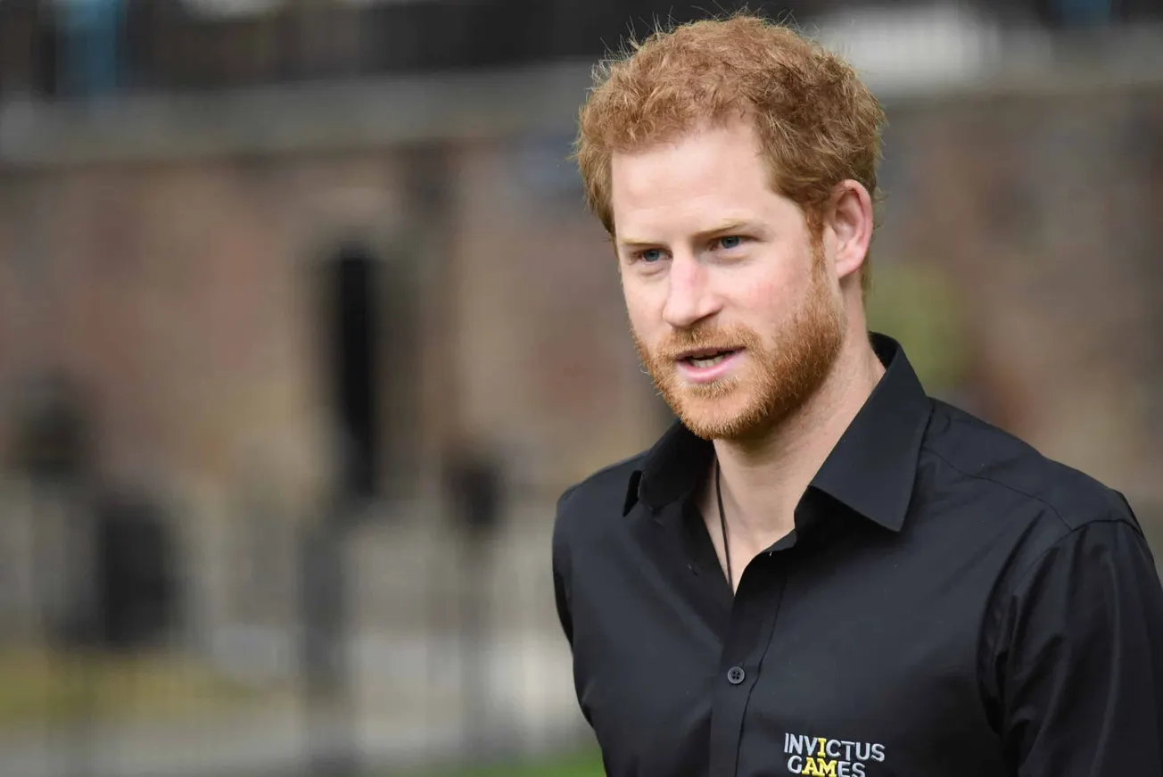 Prince Harry Receives Apology from Murdoch's papers. Photo of Prince Harry at an outdoor press event, wearing an Invictus gam
