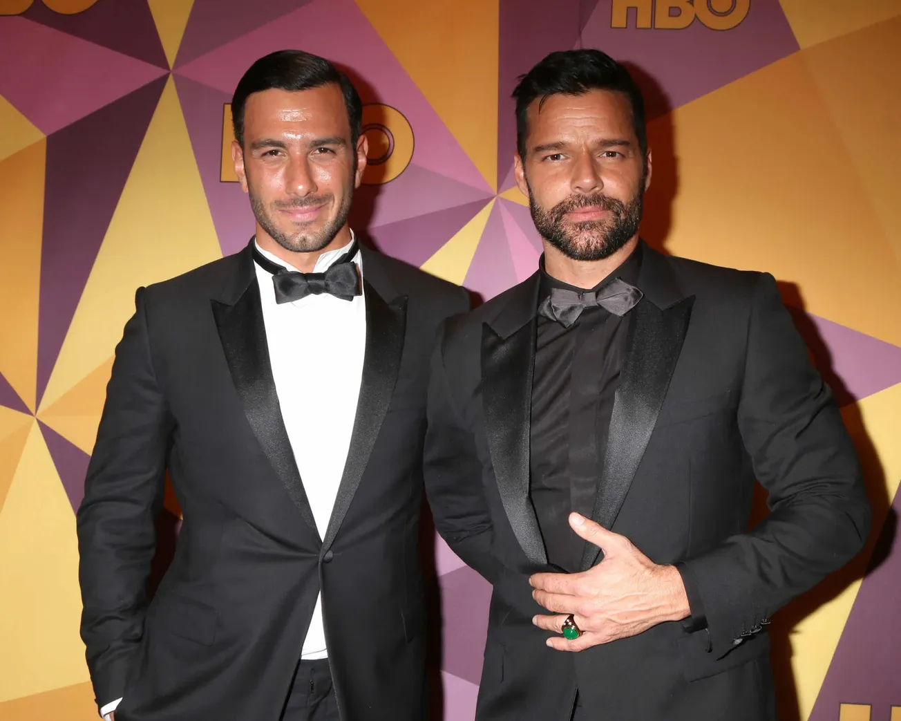 Jwan Yosef and Ricky Martin pose together in tuxedos at a press event. Today they have announced they are ending their marria