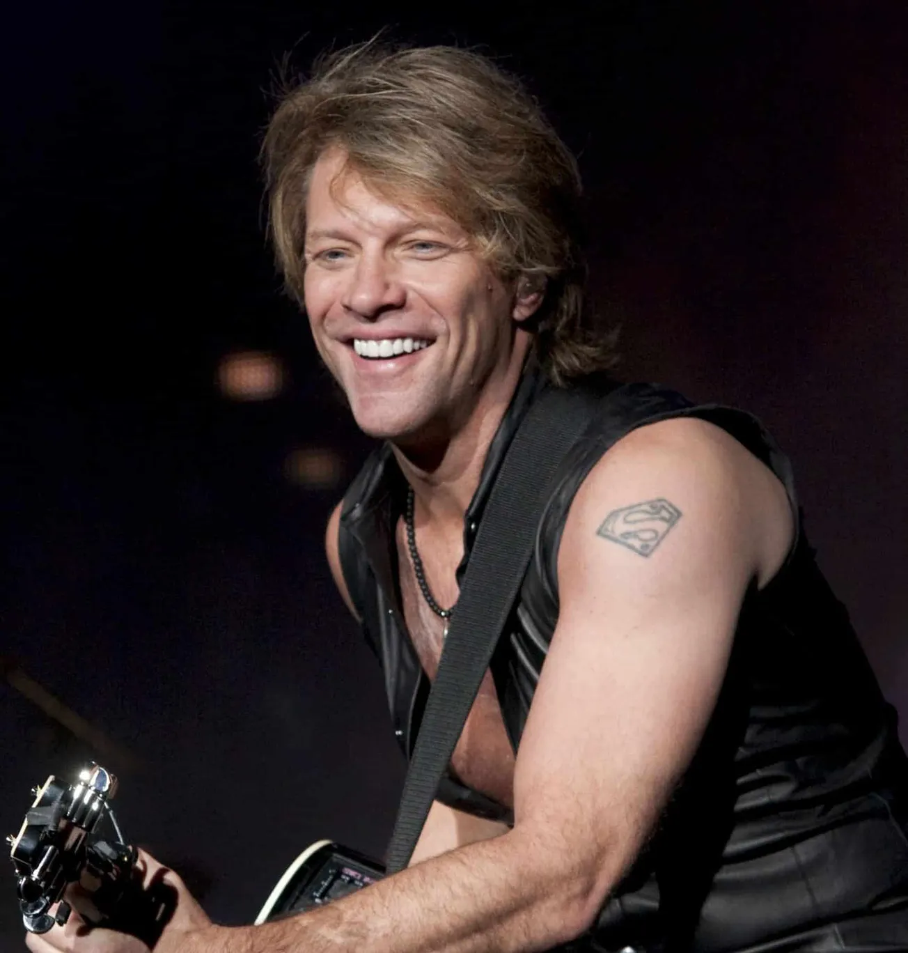 Jon Bon Jovi performing on stage smiling.