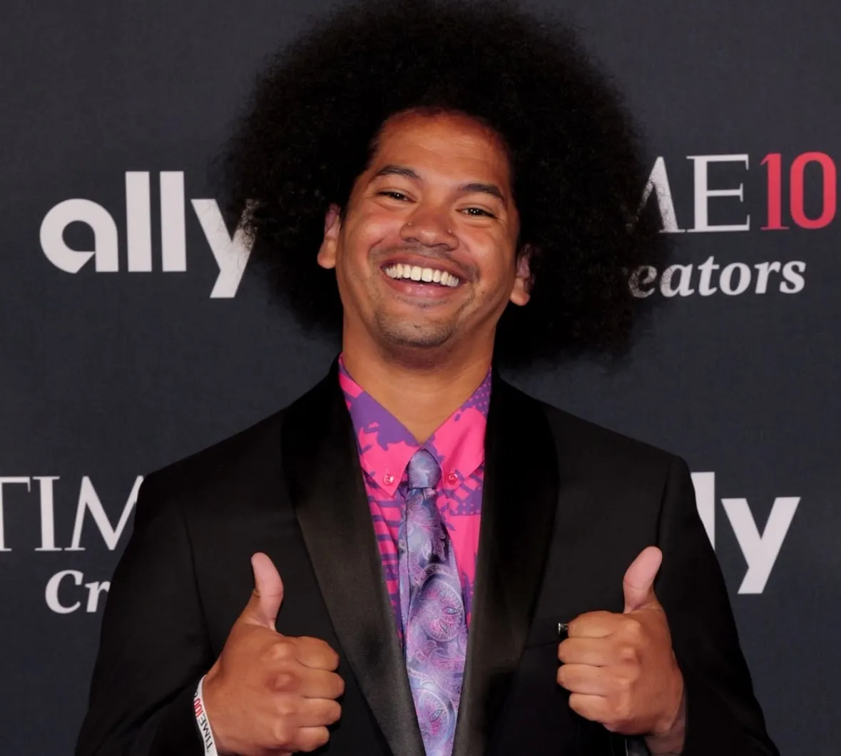 Mychal Threets with two thumbs up, smiles at a press event