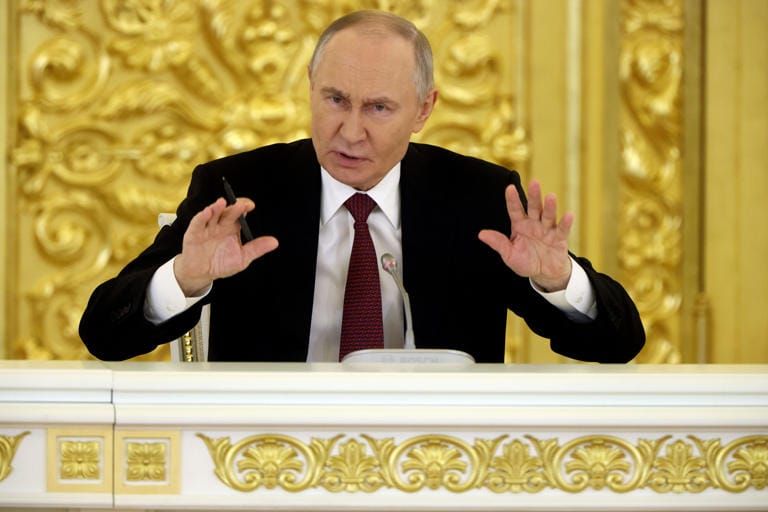Putin giving a speech in Moscow with an angry face, threatening Britain