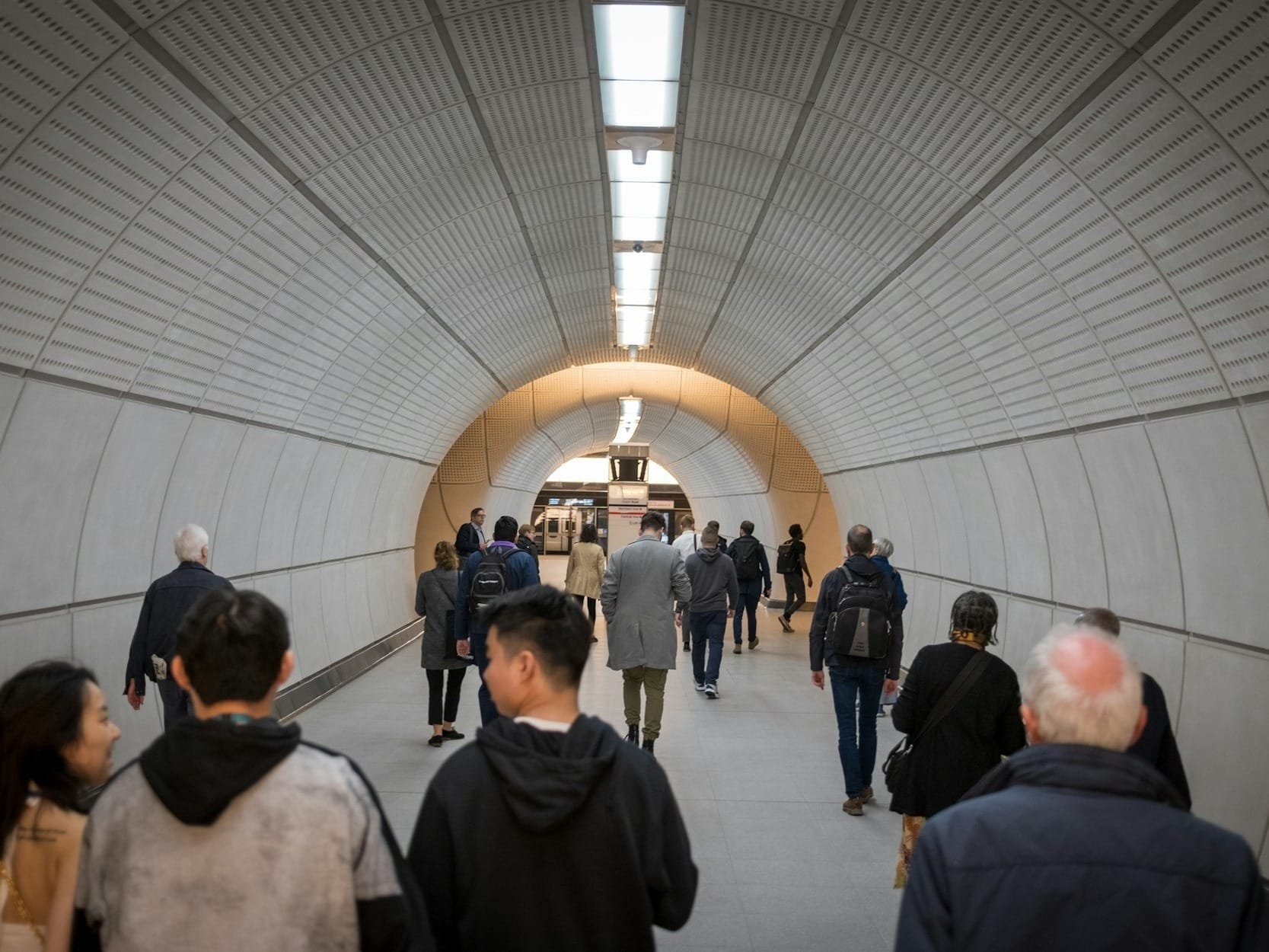 a group of people walking through a tunnel