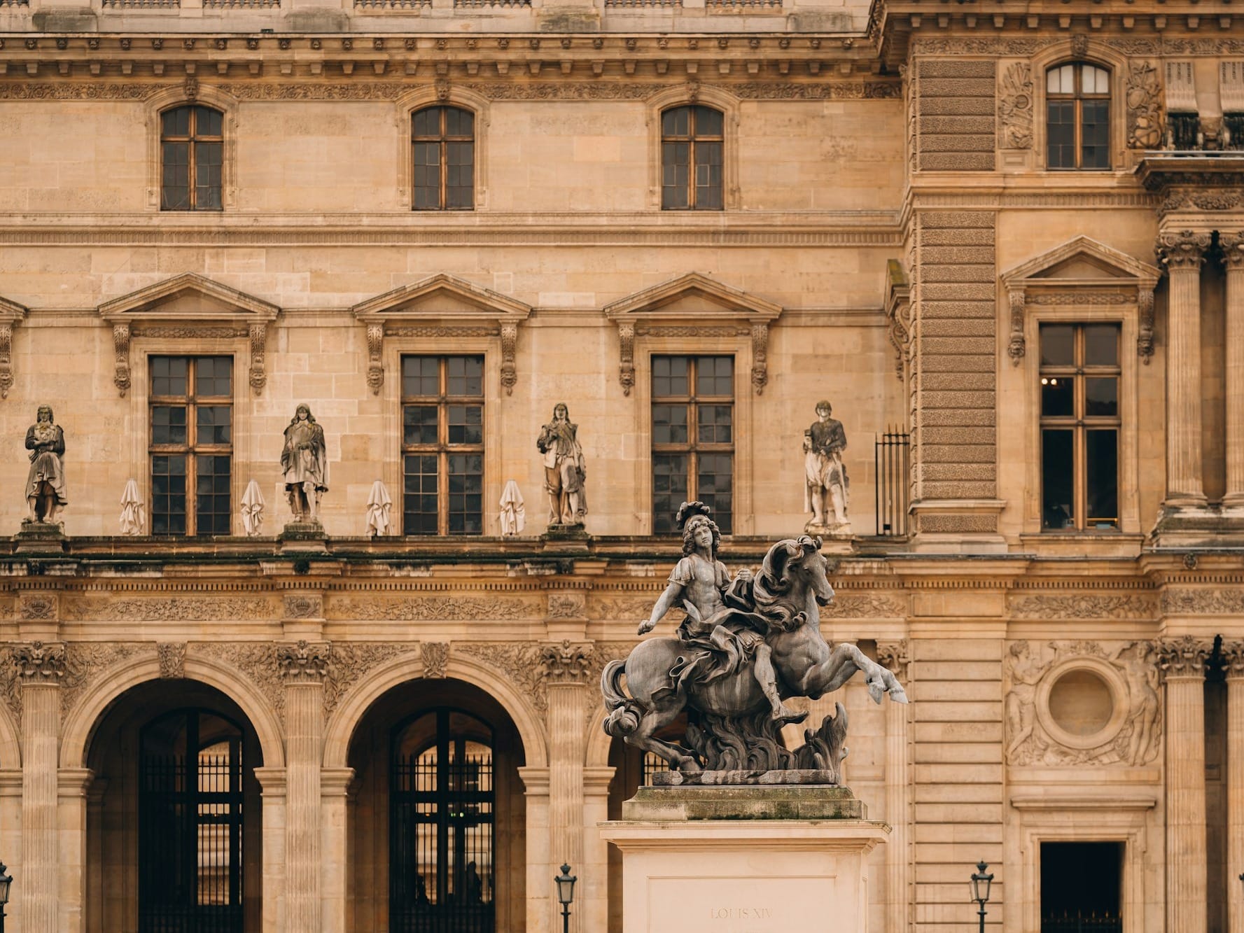a statue of a man riding a horse in front of a building