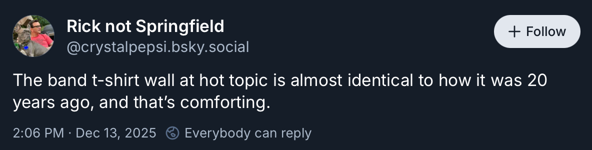 A post from Bluesky that says "The band t-shirt wall at hot topic is almost identical to how it was 20 years ago, and that’s comforting."