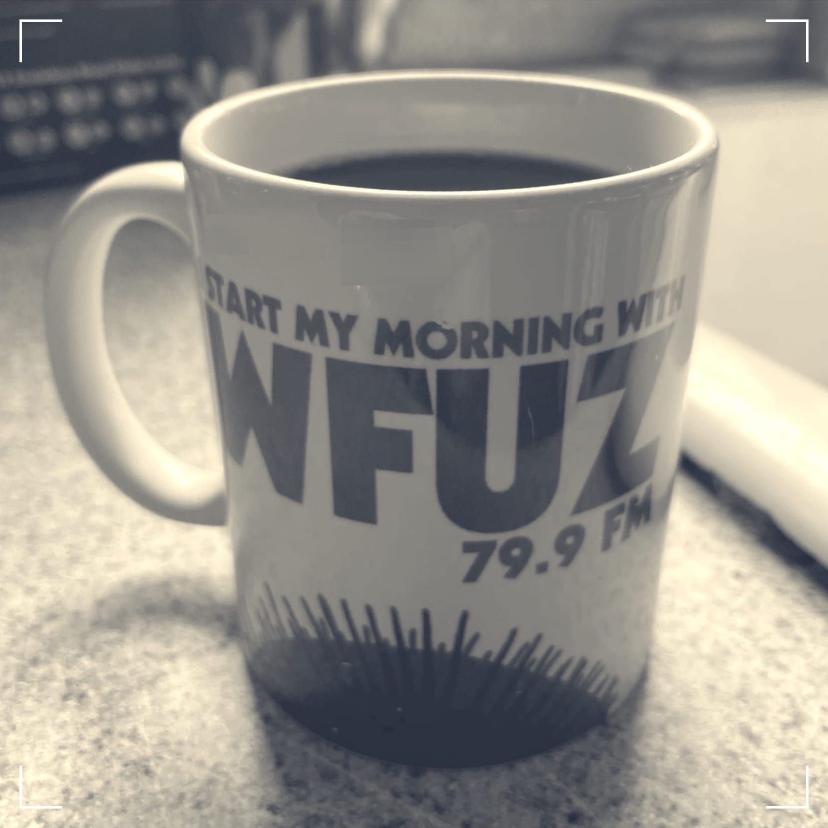 A coffee cup that reads "I start my morning with WFUZ 79.9FM"