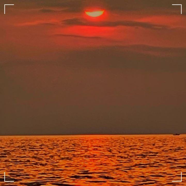 The sun is cutting through cirrus clouds 20 minutes before sunset over Lake Michigan, near Luddington, MI.