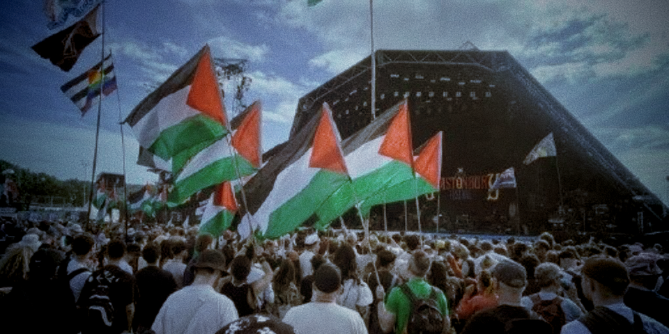 photo from glastonbury 2025 showing loads of palestine flags being waved in a crowd in front of a stage